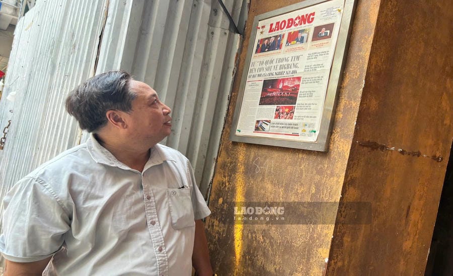 Mr. Bui Van Chan, 60 years old, reads Lao Dong newspaper at the newspaper frame in front of house number 51 Hang Bo. Photo: Minh Phuong