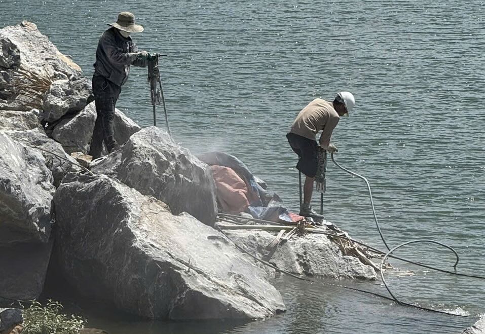 Pour draguer les calcaires glissés dans la rivière Gianh, l'entreprise a procédé au forage et au transport des pierres vers le rivage. Photo: Comité populaire de la commune de Tuyen Binh
