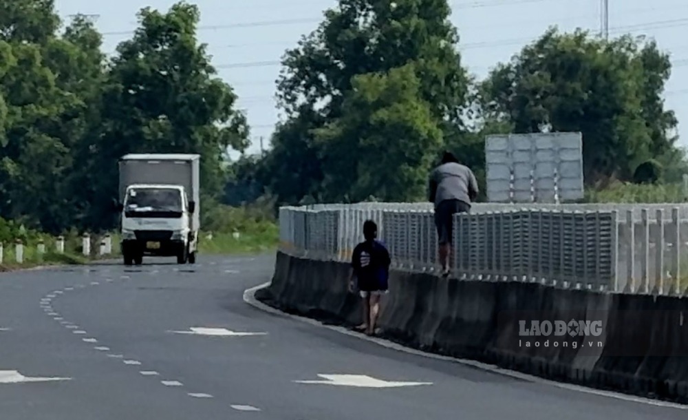 Người đi bộ cũng liều mình trèo qua dải phân cách. Ảnh: Tạ Quang