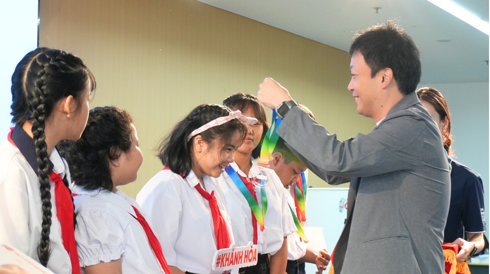 Representatives of Acecook Vietnam Company present gifts and medals to children participating in the Happiness Journey 2026 program. Photo: Acecook Vietnam