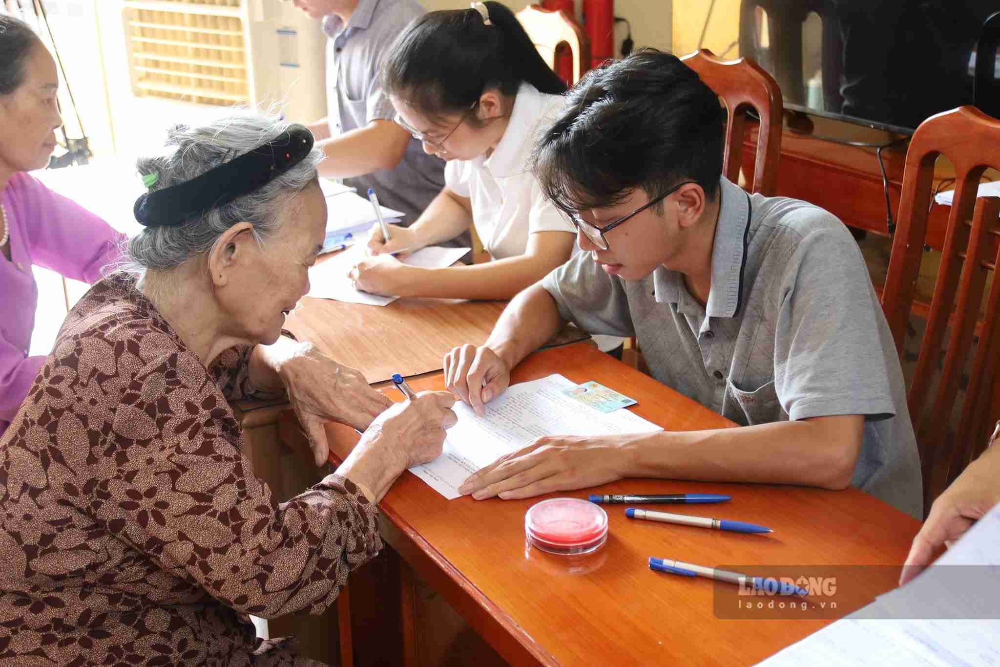 People in Binh De village carry out procedures to receive compensation and support for site clearance for the Lao Cai - Hanoi - Hai Phong railway project. Photo: Mai Huong
