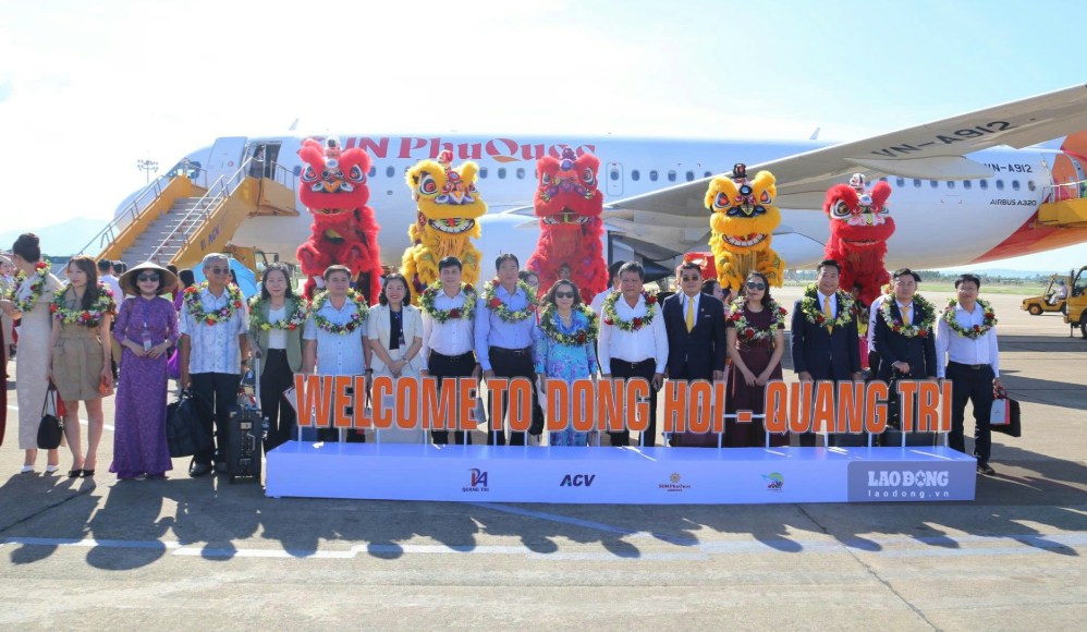 Les délégués et les passagers prennent des photos souvenirs devant l'avion effectuant le premier vol sur la liaison Cam Ranh - Đồng Hới. Photo: Nguyễn Luân