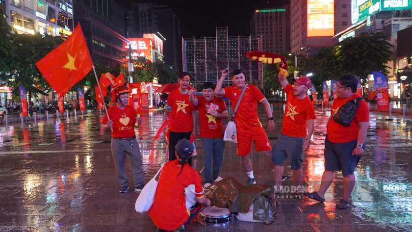 Cổ động viên mang cờ đỏ sao vàng, băng rôn đến phố đi bộ Nguyễn Huệ từ sớm để cổ vũ đội tuyển Việt Nam. Ảnh: Thái Bảo.