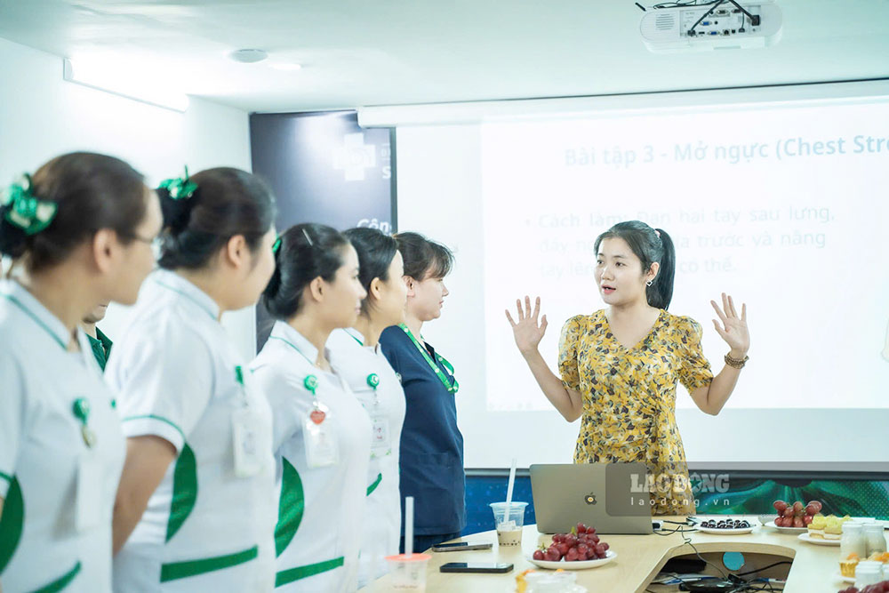 Le médecin partage des connaissances et guide les exercices de soins du cou et des épaules pour les personnes qui restent assises souvent et qui font peu d'exercice. Photo: Trần Thi