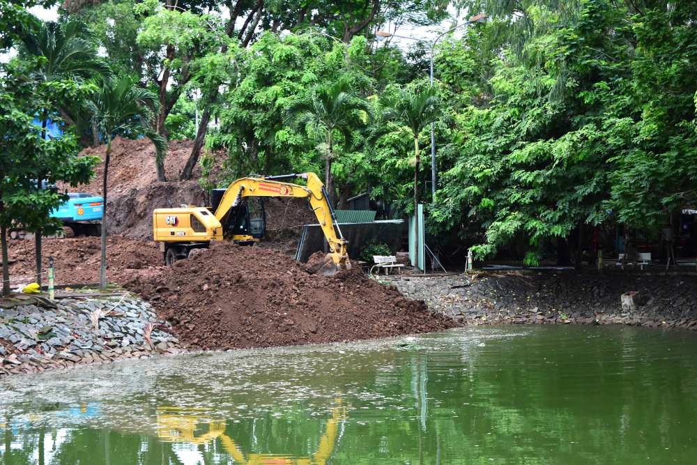 Functional forces dig and treat soil in the lake area at Le Thi Rieng Park to search for and repatriate martyrs' remains. Photo: Ho Chi Minh City Command