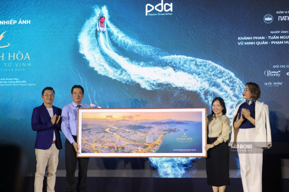 Representatives of the organizing unit presented the photo "Nha Trang Bay - brightening the ocean flow" by author Pham Hung to leaders of the Provincial People's Committee, leaders of the Department of Culture, Sports and Tourism. Photo: Phuong Linh