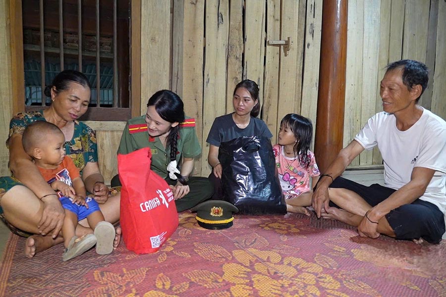 Lương Thị Hiếu trao quà cho bà con xóm Môn Sơn, xã Nghĩa Hành (Nghệ An). Ảnh: Công an tỉnh Nghệ An