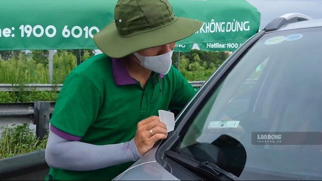 Sticking VETC non-stop toll cards. Photo: Minh Anh.