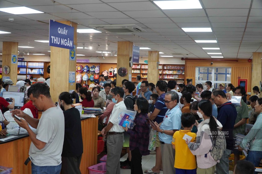 Phụ huynh xếp hàng chờ thanh toán sách giáo khoa tại Nhà sách và Thiết bị Trường học Nguyễn Tri Phương sáng 19.8. Ảnh: Ngọc Ánh