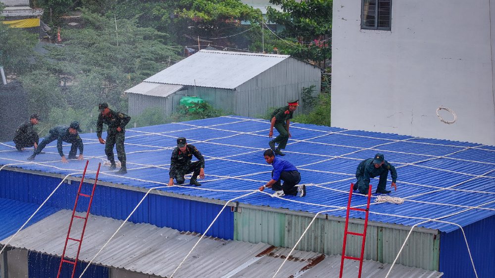 Các lực lượng tham gia diễn tập thực hành giúp nhân dân gia cố, chằng chống nhà cửa. Ảnh: Phương Vũ/Bộ CHQS An Giang