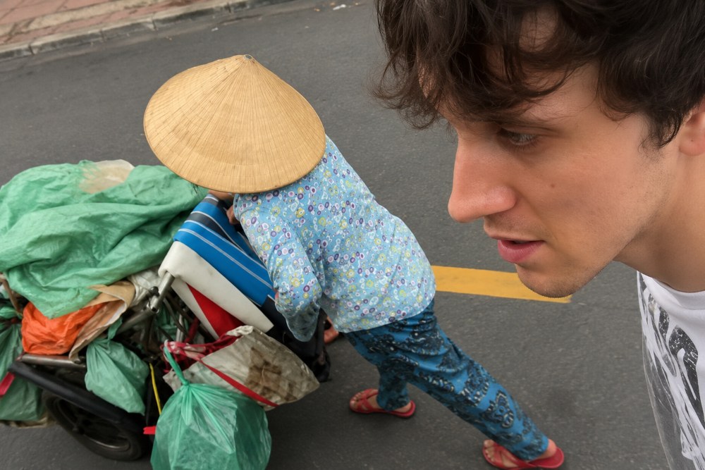 Not knowing English, Ms. Phung Thi Tam still used simple gestures to lead the Western tourist to find her lost shoes. Photo: Joe Brady