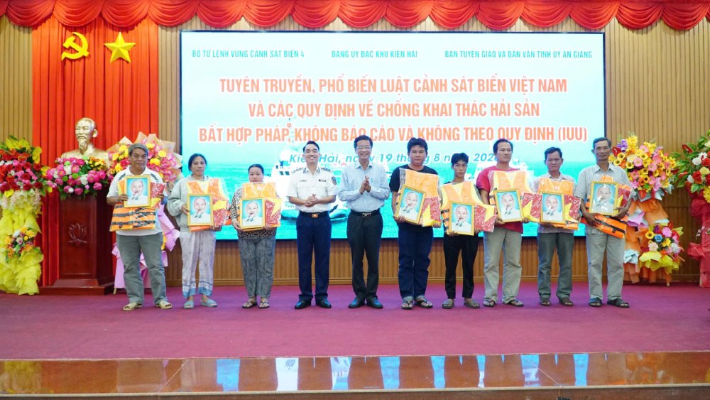Đại diện Bộ Tư lệnh Vùng Cảnh sát biển 4 và lãnh đạo địa phương trao tặng cờ Tổ quốc, ảnh Bác Hồ và áo phao cho chủ tàu, thuyền trưởng. Ảnh: BTL Vùng CSB4