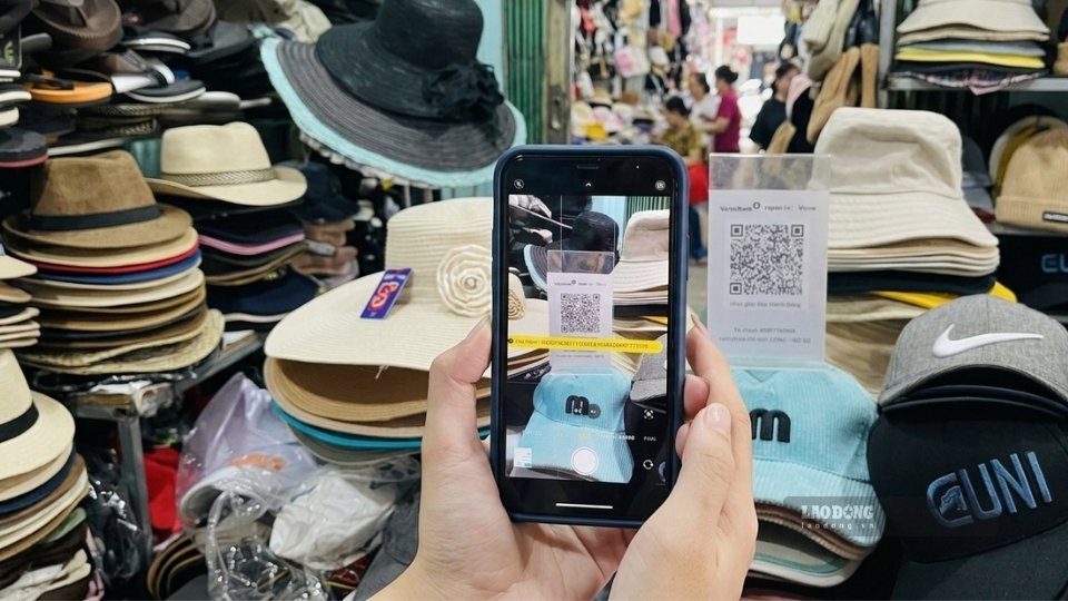 Tiểu thương tại chợ truyền thống Vĩnh Long tiếp cận các giải pháp thanh toán số, góp phần thúc đẩy chuyển đổi số trong kinh doanh. Ảnh: Hoàng Lộc