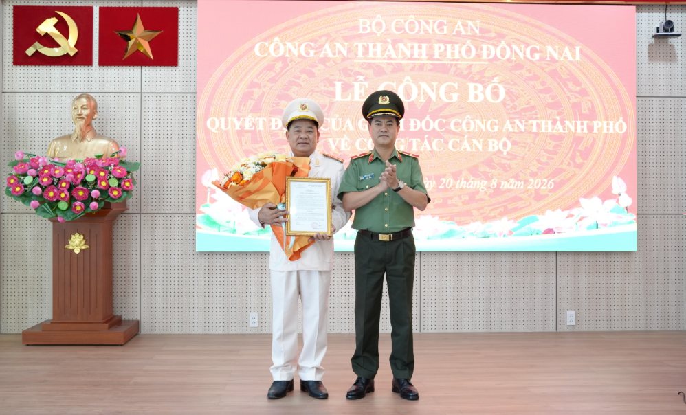 Major General Nguyen Duc Hai - Director of Dong Nai City Police (right) - presents the transfer decision to Colonel Nguyen Van Vo. Photo: Dong Nai City Police