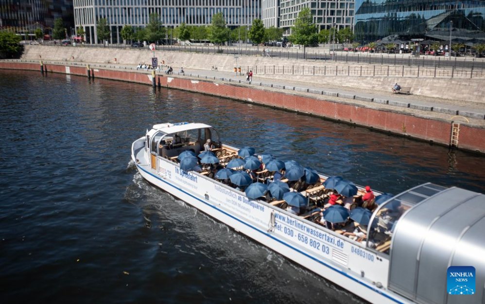 Tourists take a boat sightseeing and use umbrellas due to the heat in Berlin, Germany, June 24, 2026. Photo: Xinhua