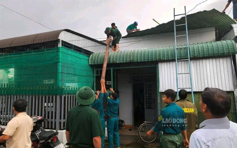 Các lực lượng phối hợp hỗ trợ người dân lợp lại mái nhà sau lốc xoáy. Ảnh: Minh Vũ