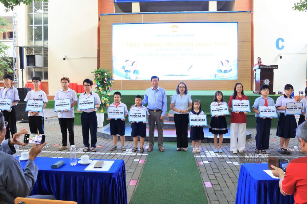 Ông Vũ Ngọc Tuất và bà Hoàng Mai Quỳnh Hoa - Chủ tịch Ủy ban MTTQ Việt Nam phường trao học bổng cho các em tại ngày hội. Ảnh: Trúc Mai
