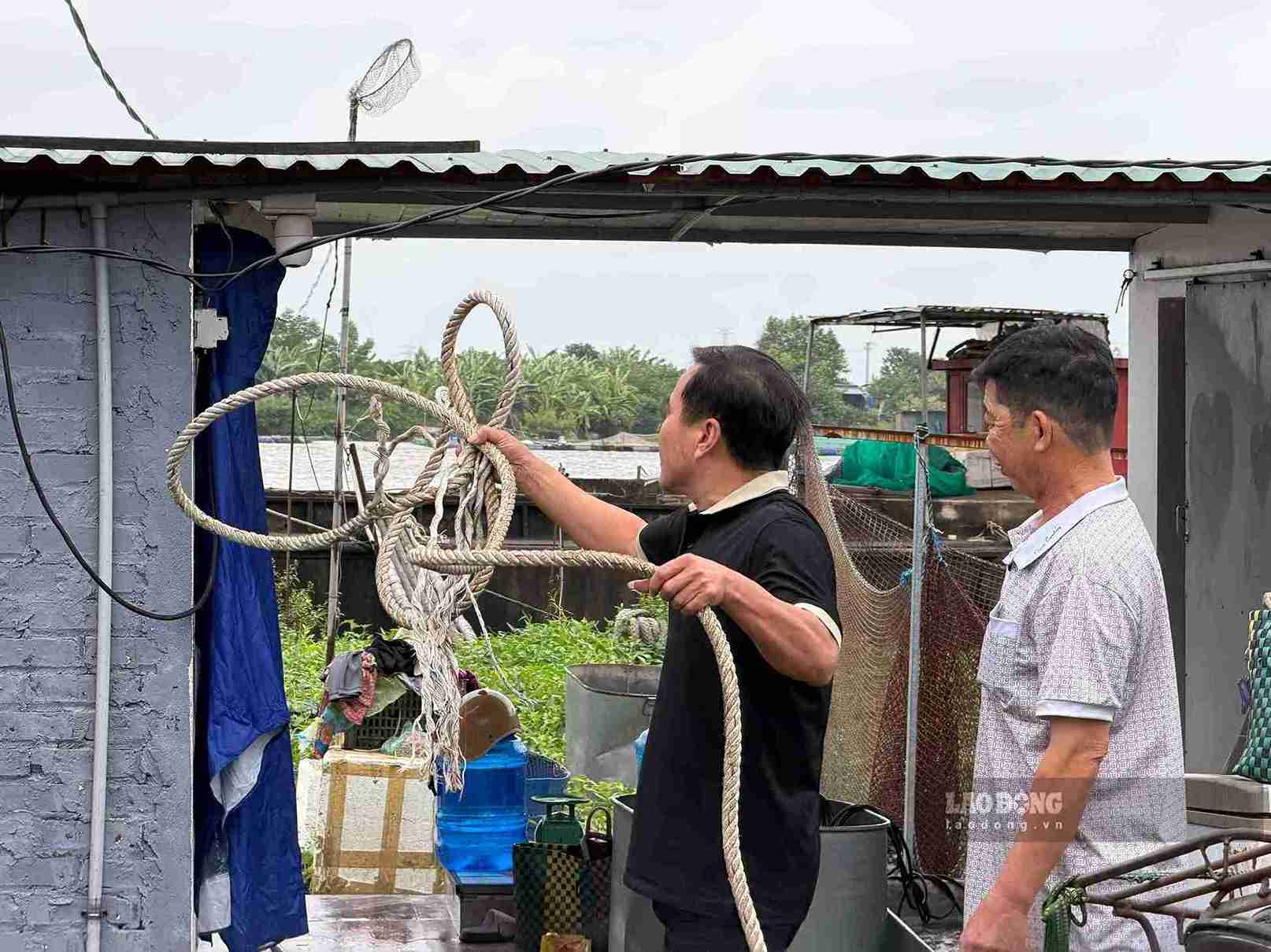 Residentes a lo largo del río en el barrio de Hai Duong aseguran y amarran barcos antes de la tormenta número 4. Foto: Mai Huong
