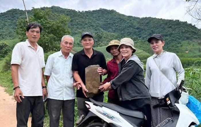 The stone stele engraved with the name and date of martyr Tran Dinh Hoe's sacrifice is taken out of the forest by people. Photo: Huong Hiep Commune People's Committee