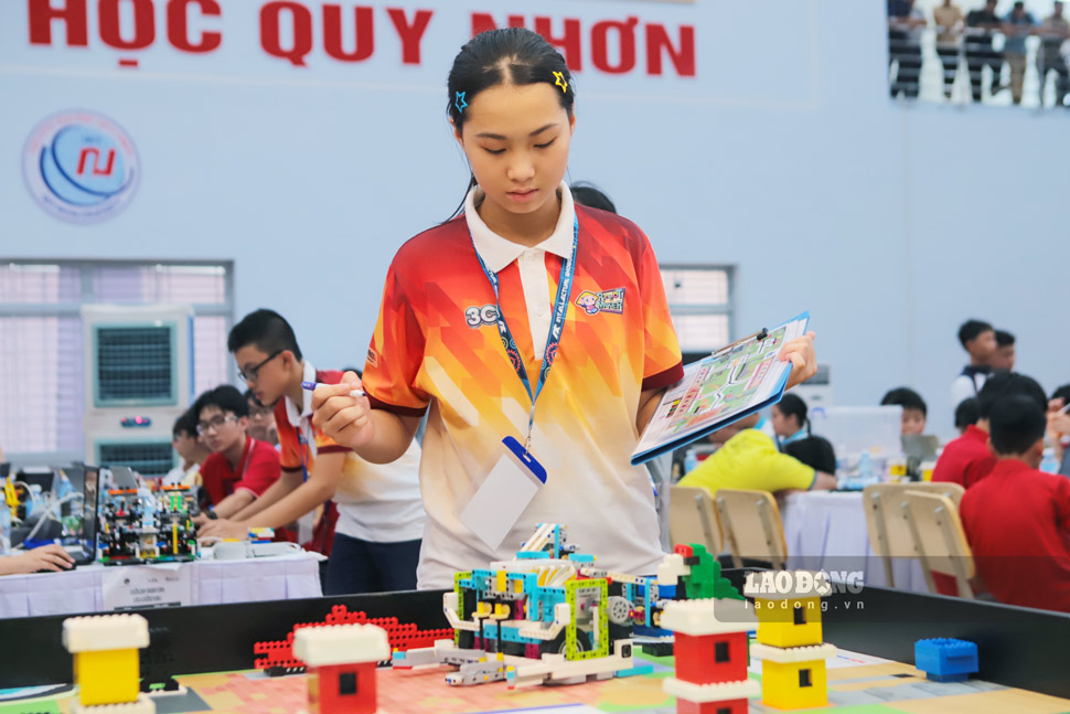 Em Đỗ Thị Thanh Bình, thành viên Đội Robotmaker 3C, theo dõi robot thực hiện nhiệm vụ trên sa bàn. Ảnh: Hoài Phương