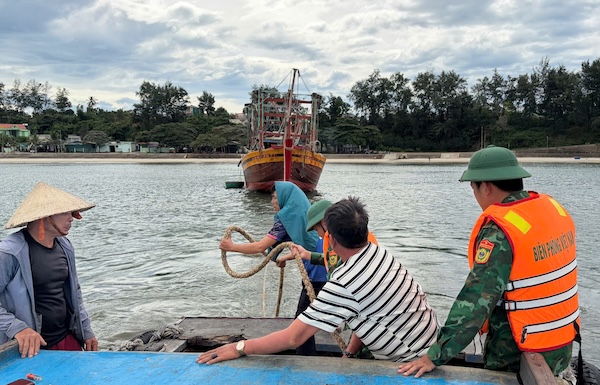 Fishing boats are mobilized to move closer to the stranded boat, then use rope to pull the boat out of the shallow area. Photo: Cua Tung Border Guard Station