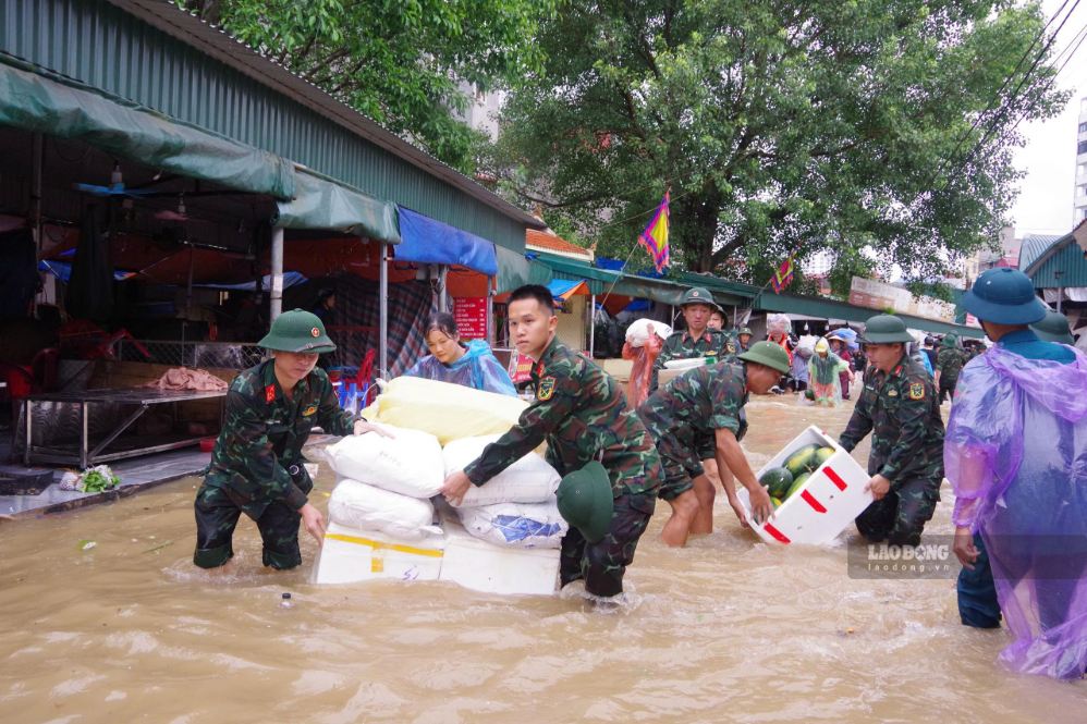 Rain and floods caused Gieng Vuong market to be widely flooded, officers and soldiers were mobilized to support small traders in moving goods. Photo: Duong Nguyen