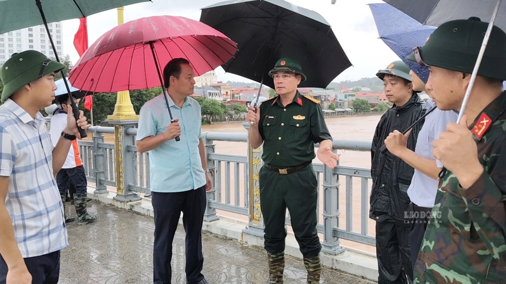 Đại tá Mai Xuân Phong trao đổi phương án sử dụng lực lượng ứng cứu, di dời các hộ dân trong vùng bị ngập úng với cấp ủy, chính quyền các phường Đông Kinh, Tam Thanh, Lương Văn Tri. Ảnh: Dương Nguyên
