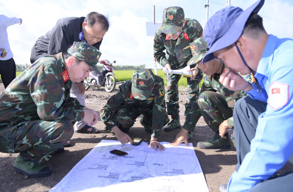 The working group conducted field surveys to compare terrain, verifying locations suspected of having martyrs' graves on the map. Photo: Phuong Vu/An Giang Military Command