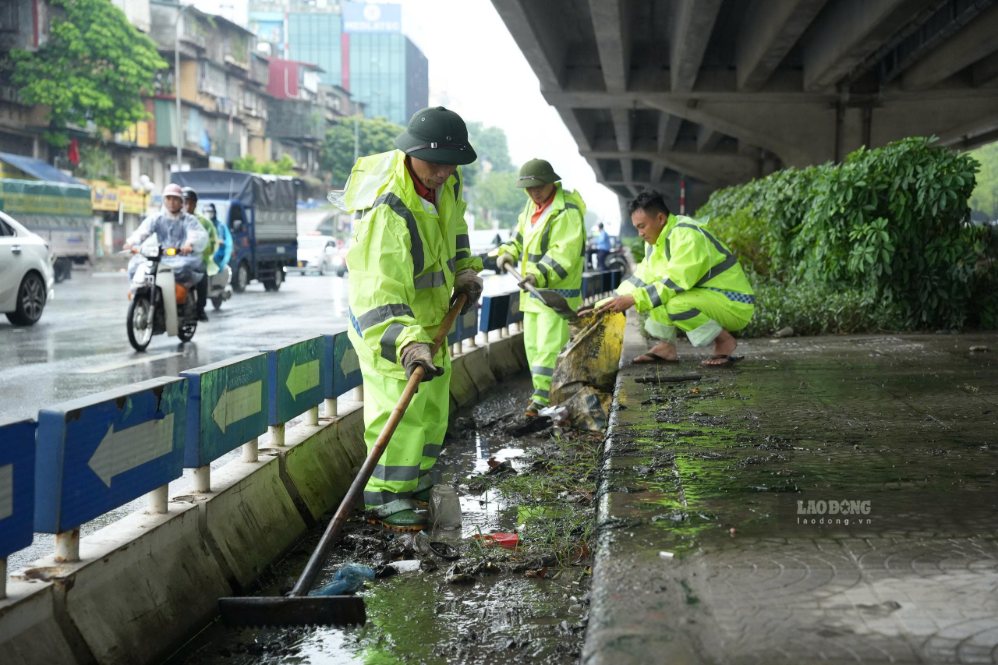 Workers brave the rain to renovate traffic infrastructure to serve National Day September 2, morning of August 23. Photo: Song Huu