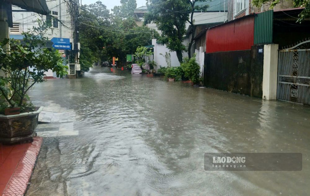 Lực lượng chức năng đặt biển cảnh báo ngập sâu tại tuyến phố Phụ Thọ 3, phường Hạc Thành, tỉnh Thanh Hóa. Ảnh: Quách Du 