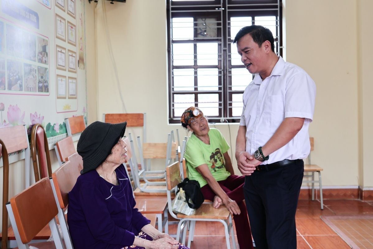 Đồng chí Phạm Trí Tuyến, Trưởng phòng Văn hóa - Xã hội đặc khu Cát Hải, thăm hỏi, động viên các cụ đang tạm thời tránh lụt, bão tại trường học. Ảnh: UBND đặc khu Cát Hải