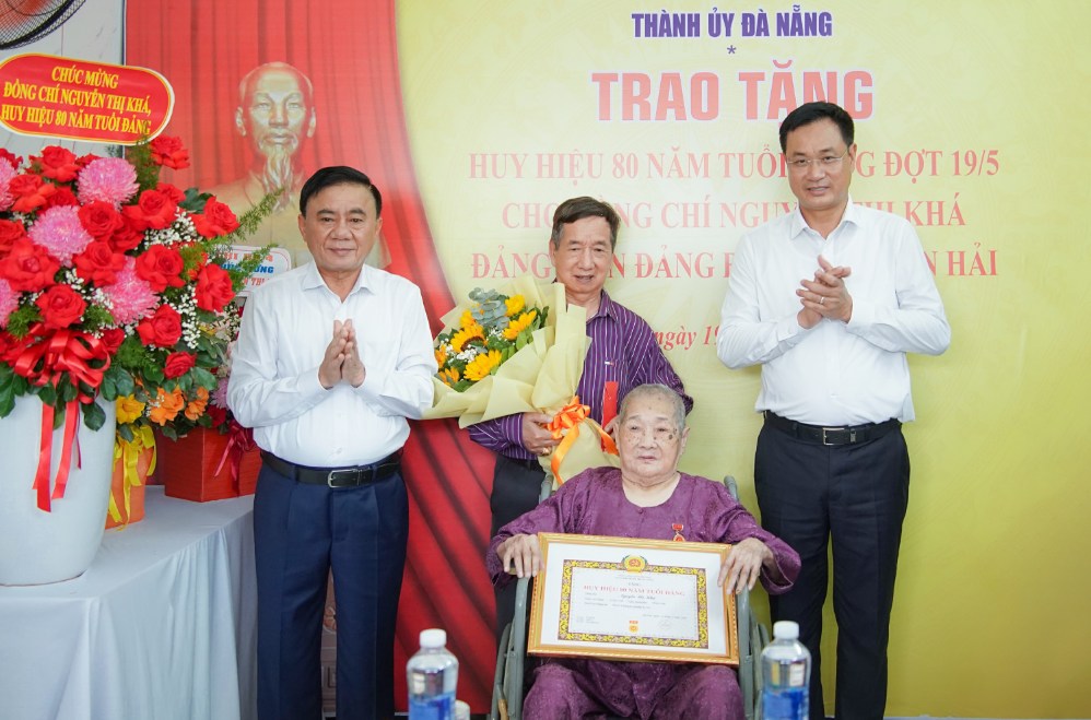 Standing Secretary of the Secretariat Tran Cam Tu awarded the 80-year Party Badge to Party member Nguyen Thi Kha, expressing gratitude for her great contributions to the revolutionary cause. Photo: Mai Quang (Da Nang City e-Portal)