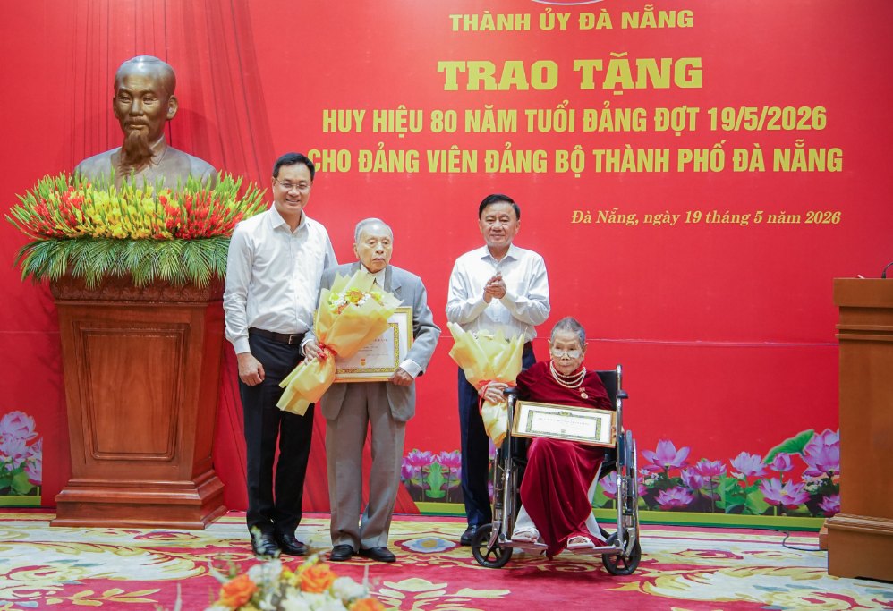 El Secretario Permanente del Secretariado Trần Cẩm Tú y el Secretario del Comité del Partido de la ciudad de Đà Nẵng Lê Ngọc Quang entregan la Insignia de 80 años de militancia en el Partido a la miembro del partido Bùi Thị Liễu (portada derecha). Foto: Mai Quang (Portal de Información Electrónica de la ciudad de Đà Nẵng)