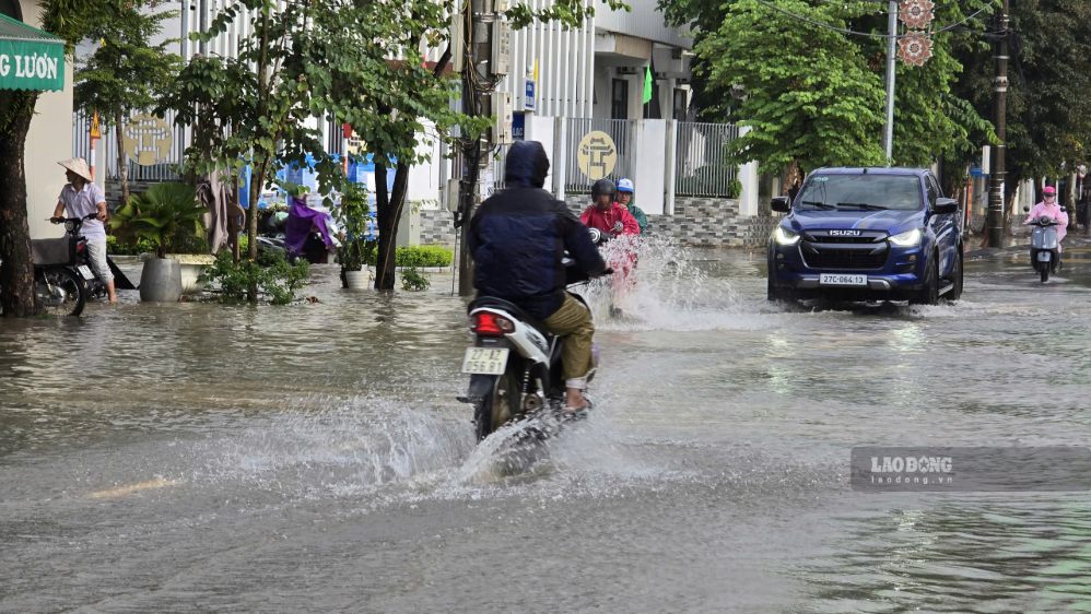 Nước ngập sâu khiến những người di chuyển bằng phương tiện nhỏ rất dễ ngã. Ảnh: Thành An