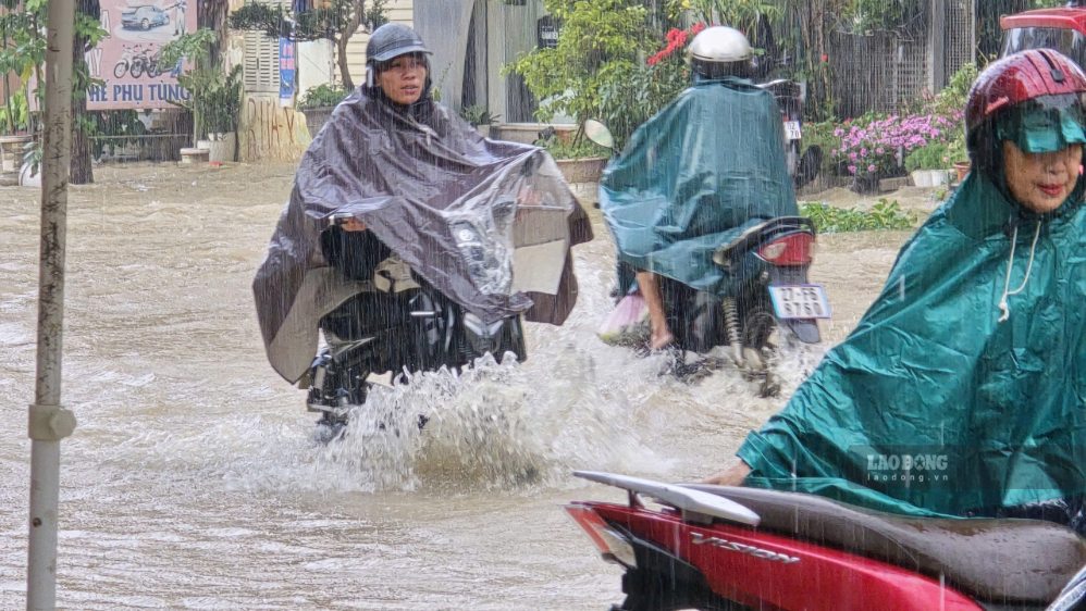 Người dân gặp khó trong di chuyển trên đường ngập. Ảnh: Thành An