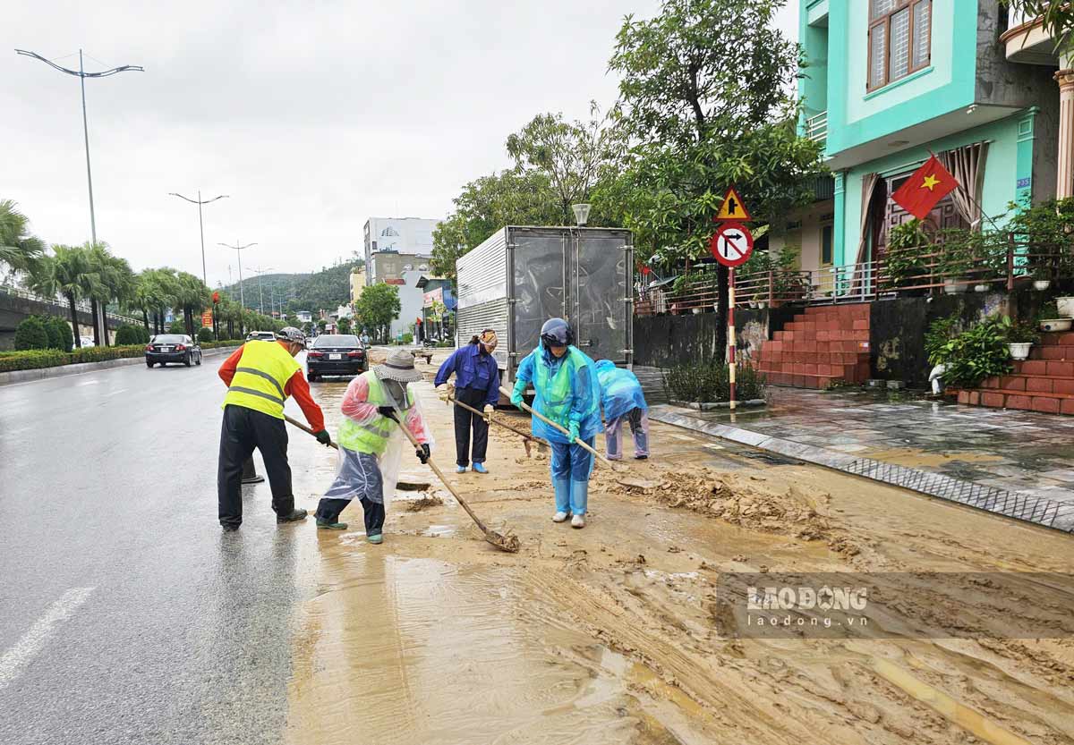Lực lượng chức năng phường Bãi Cháy khẩn trương thu dọn bùn đất, bảo đảm lưu thông trên Quốc lộ 18, đoạn qua Khu công nghiệp Cái Lân. Ảnh: Đoàn Hưng