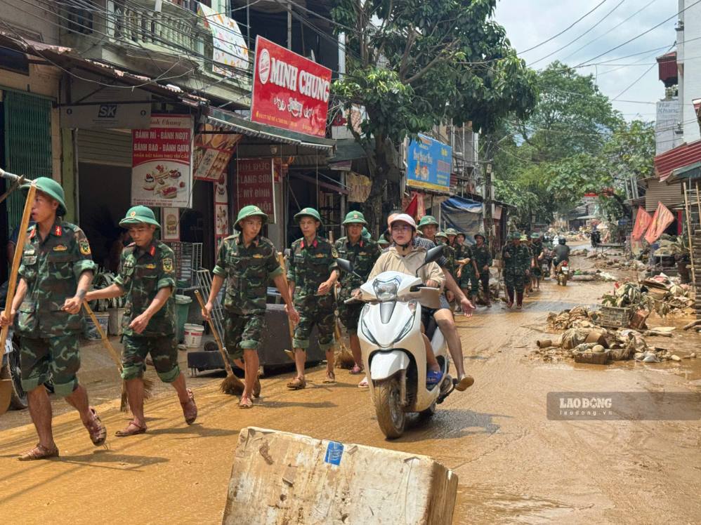 The government, along with the army, police and people, join hands to clean up after the flood. Photo: Khanh Linh