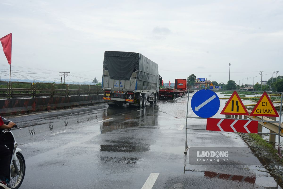 Lực lượng chức năng đặt biển cảnh báo các phương tiện khi qua điểm ngập sâu. Ảnh: Quách Du
