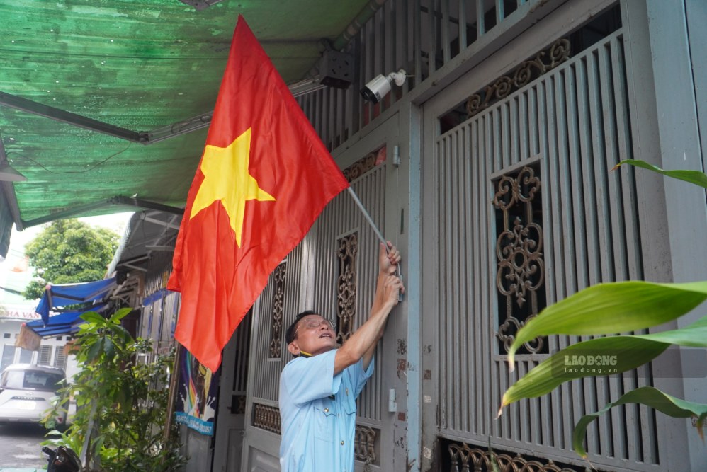 Ông Phạm Xuân Hải (ngụ phường Tân Sơn Nhất) treo cờ mừng ngày lễ 2.9. Ảnh: Minh Tâm