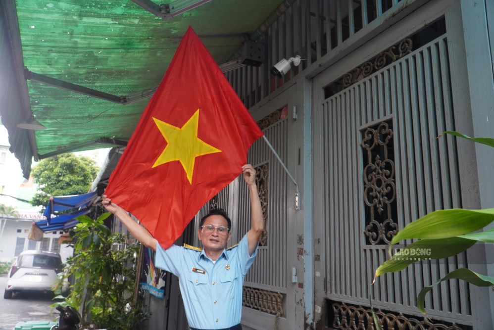 M. Phạm Xuân Hải (37 ans d'adhésion au Parti, résidant dans le quartier de Tân Sơn Nhất) se fond dans l'atmosphère de la fête du 2 septembre. Photo: Minh Tâm