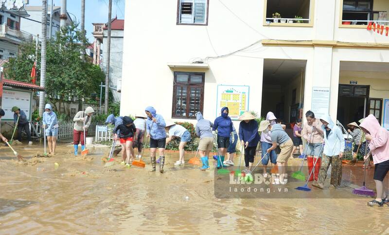 Đông đảo phụ huynh hỗ trợ giáo viên dọn dẹp lại các điểm trường sau khi nước lũ rút. Ảnh: Khánh Linh