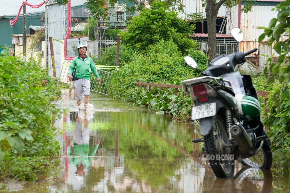 Người dân để xe phía đầu cầu rồi bì bõm lội nước di chuyển qua cầu 72 (cầu tạm). Ảnh: Sóng Hữu 