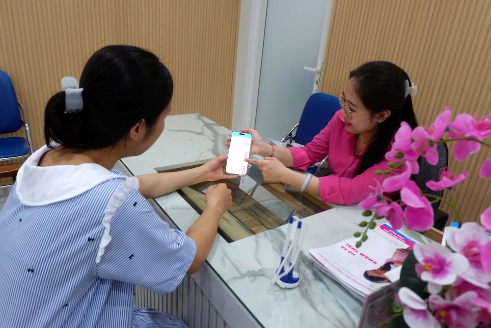 Can Tho City Obstetrics and Gynecology Hospital officially operates electronic medical records. In the photo: staff support customers on how to download application apps and use utilities right on their phones. Photo: Hospital provided