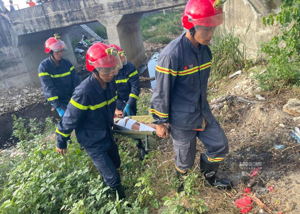 Officers and soldiers of Fire and Rescue Team Area 9, Khanh Hoa Provincial Police rescue a young man who fell into a canal by the National Highway. Photo: Phuong Linh