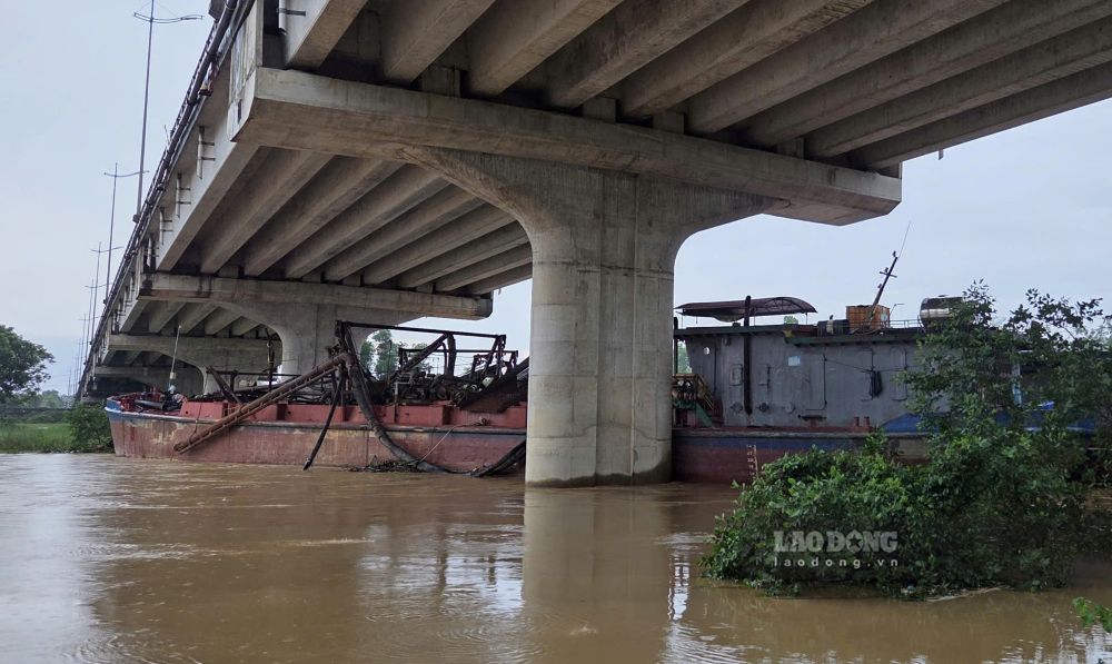 Two sand dredging boats drifted and got stuck under the bridge. Photo: Minh Hoang