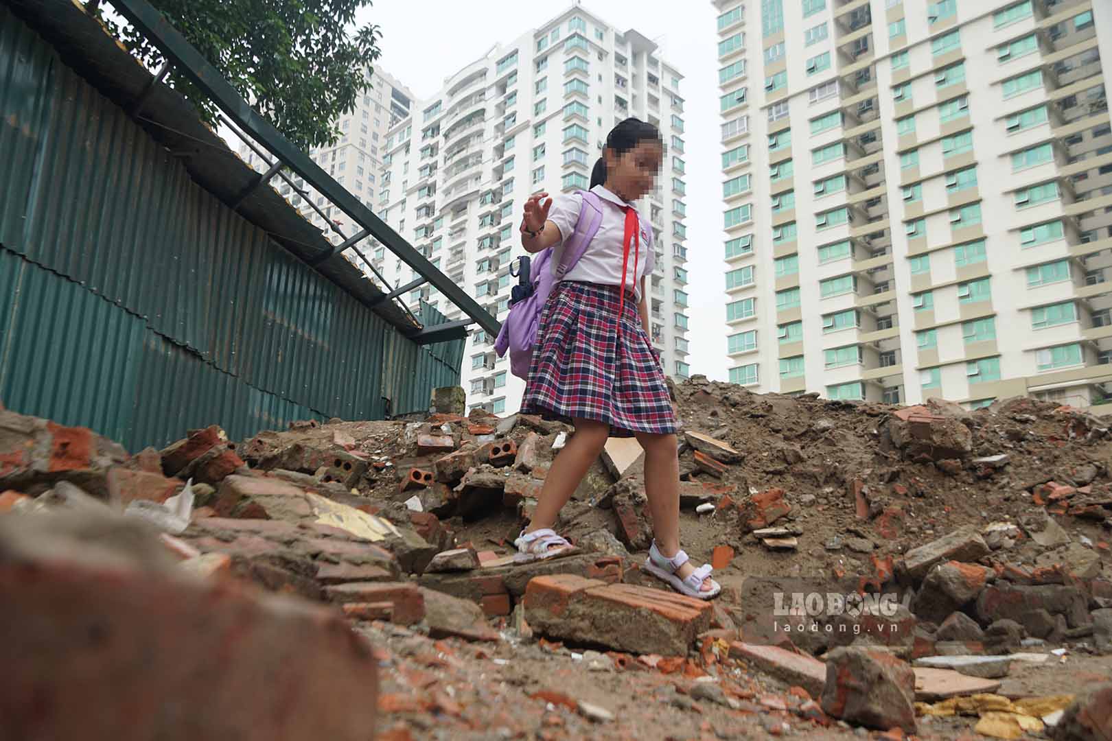 Không chỉ người đi làm, một số phụ huynh cũng dẫn con em băng qua khu vực đang thi công để đi học. Tại công trường, mặt bằng vẫn còn gạch đá và các hạng mục xây dựng chưa hoàn thiện, khiến việc đi lại tiềm ẩn nguy cơ mất an toàn.