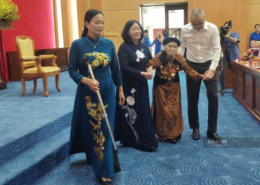 Party member Han Thi Huong, brought to her seat by leaders after speaking at the 80-year Party Badge Award Ceremony. Photo: Xuyen Dong
