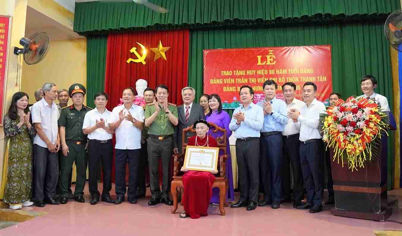 El General Lương Tam Quang - Miembro del Buró Político, Ministro de Seguridad Pública entrega la Insignia de 80 años de militancia en el Partido a la Sra. Trần Thị Viển en la comuna de Hưng Hà. Foto: Comité del Partido de la comuna de Hưng Hà