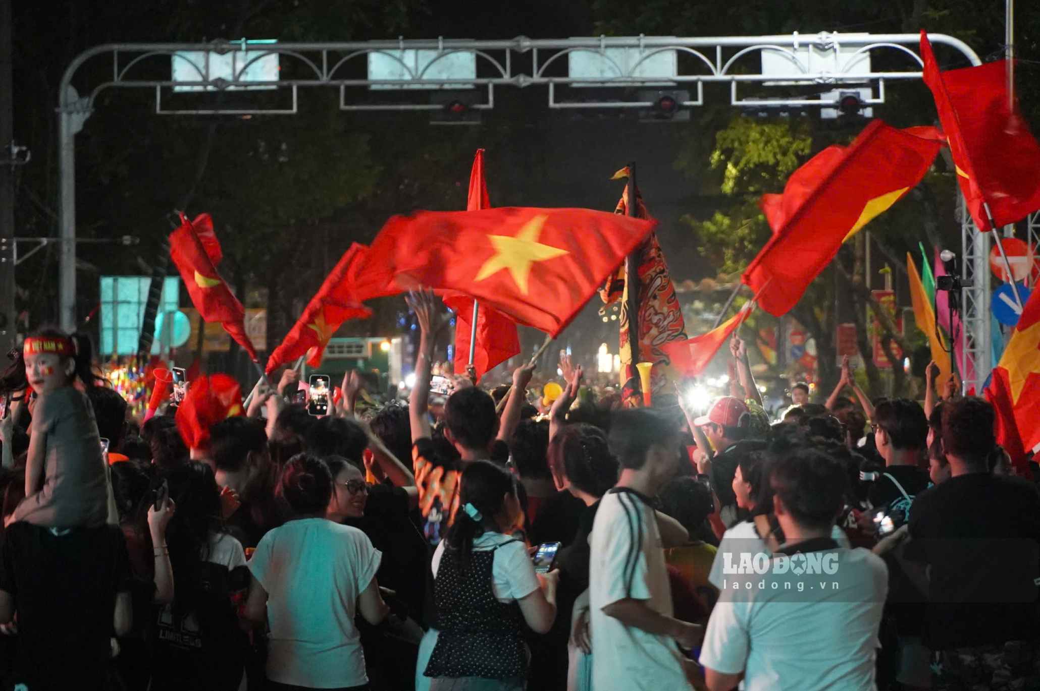 Cờ đỏ sao vàng tung bay giữa dòng người hâm mộ trên một tuyến phố ở Cần Thơ. Không ít người vừa di chuyển vừa hô vang những câu cổ vũ dành cho đội tuyển Việt Nam.