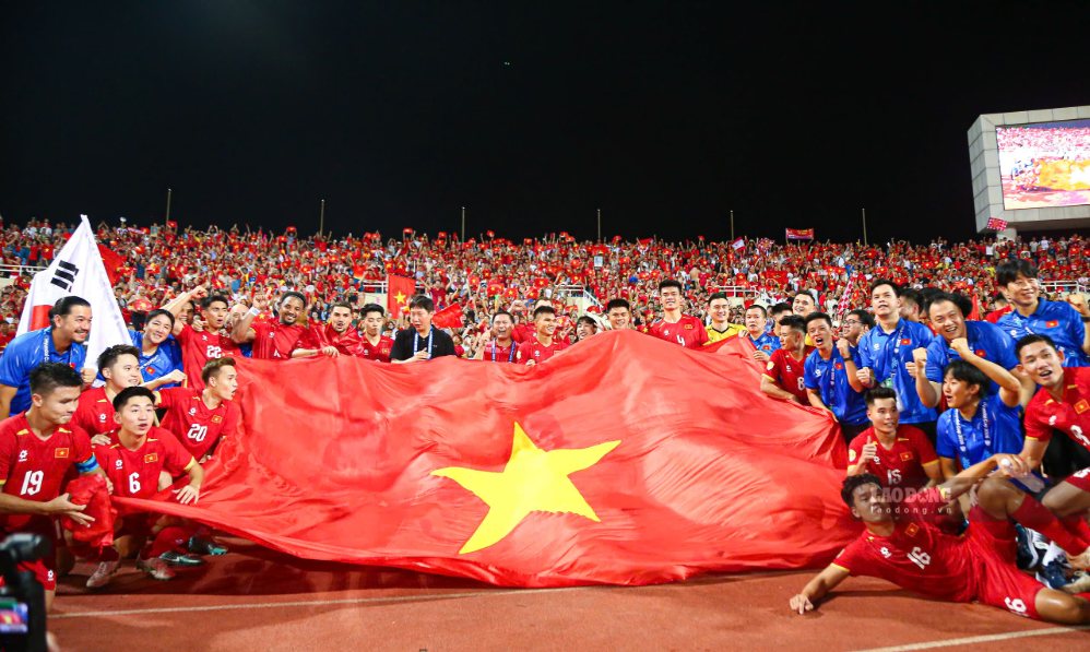 Toda la selección vietnamita celebra con la gran bandera en el estadio Mỹ Đình. Foto: Thanh Vũ